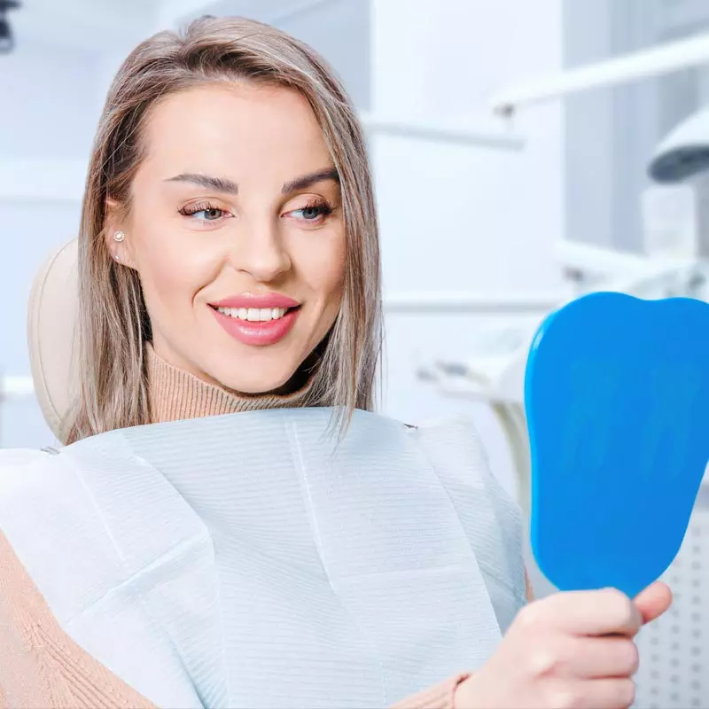 Home 1 Smiling patient after visiting her dentist in Miami Gardens
